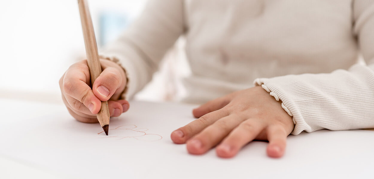 Kinderhand hält Stift, Kind malt Bild